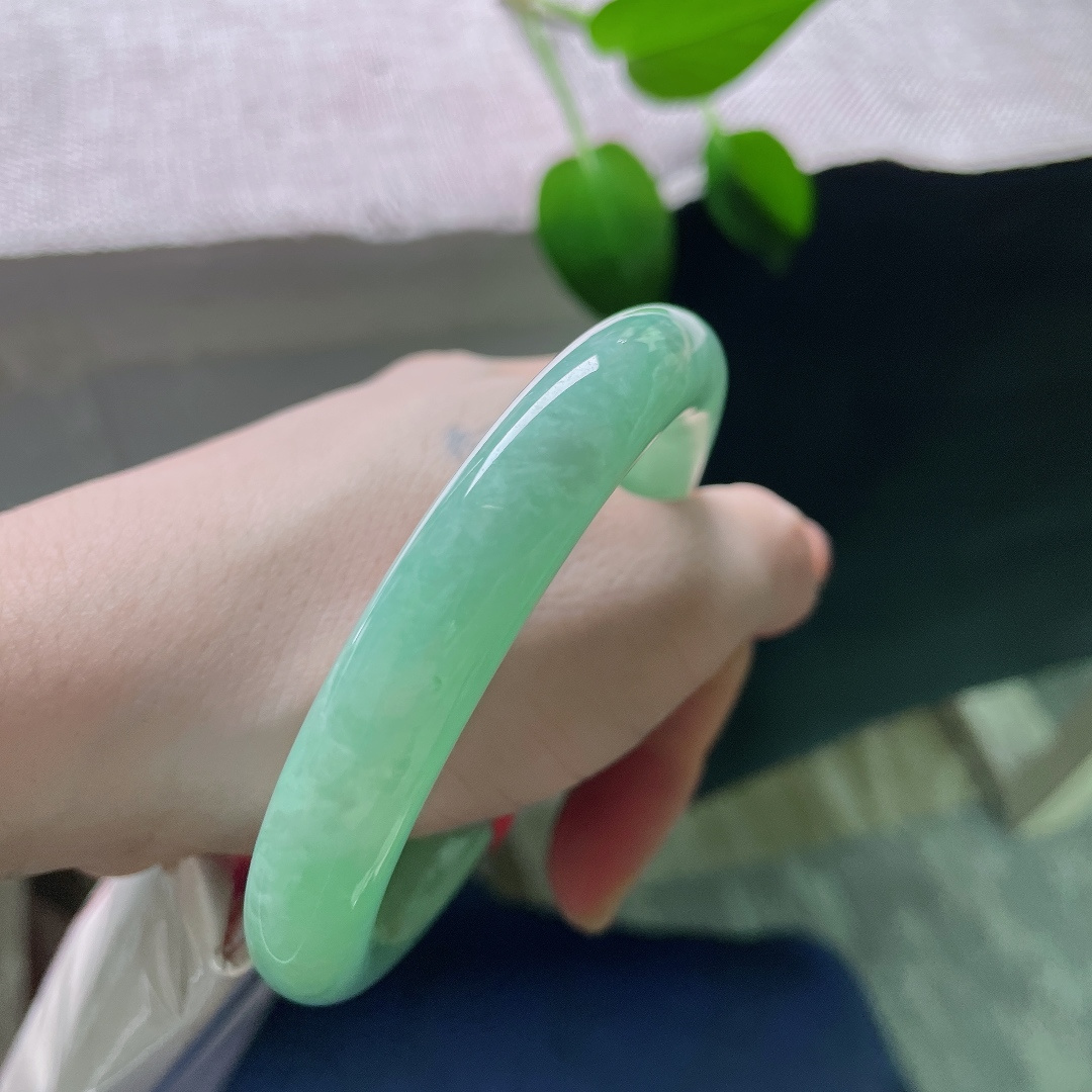 57.3/11，绿底圆条，无裂，镯身线条顺滑圆润，湖绿静谧舒缓，柔光流转，衬得肤色温润。ss59261a