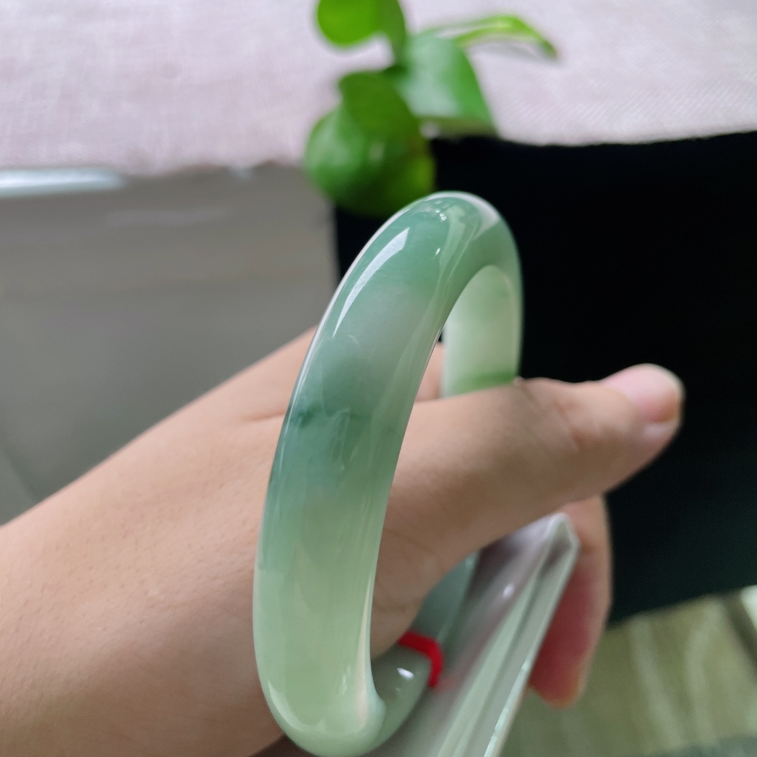 57.7/11.9/8.8，飘花正圈，皮纹，底色温润柔和，深绿色飘花随性萦绕镯身，花色写意自然，自带清雅的国风韵味。ss59753a