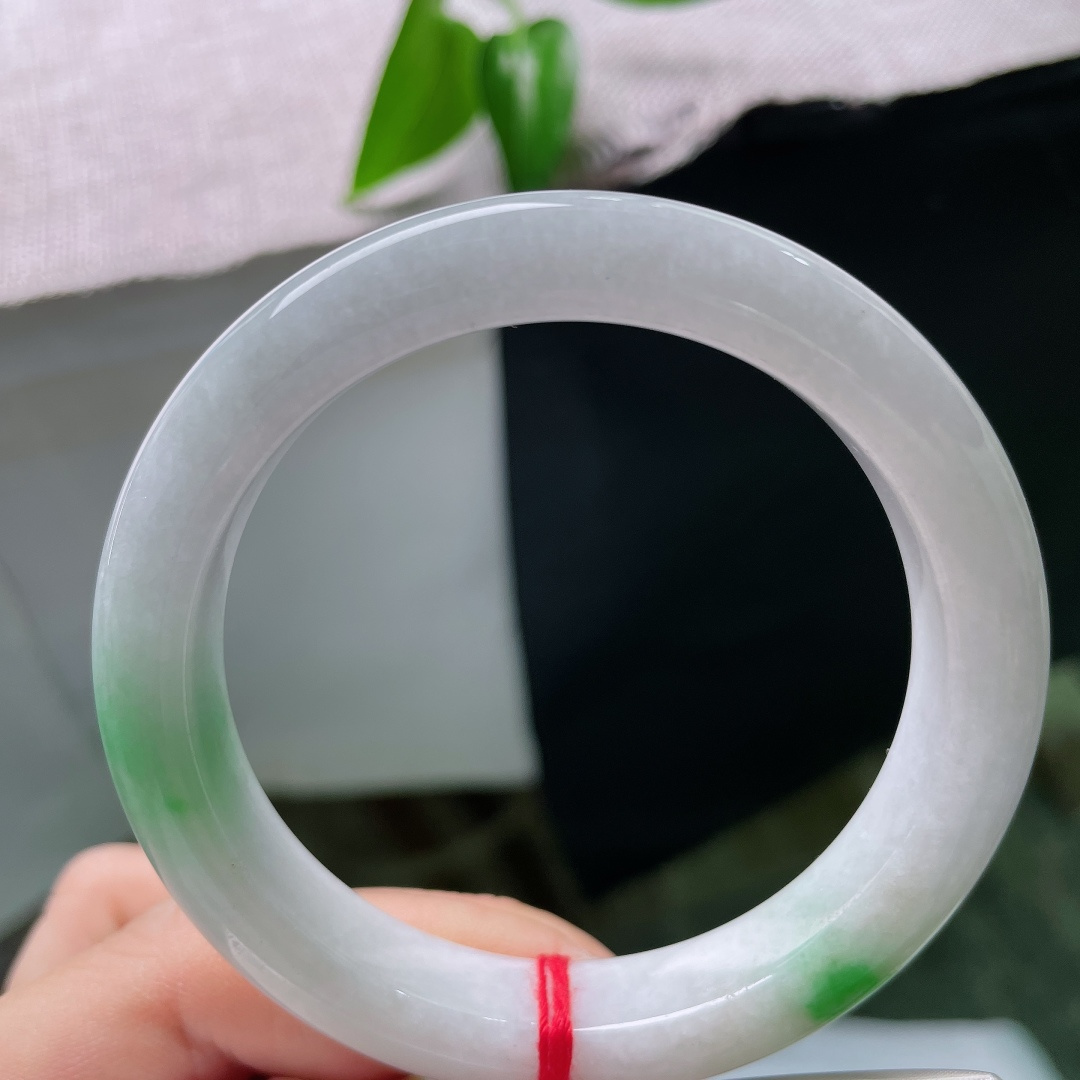 56.9/11.1/9，春彩正圈，一点皮纹，素雅白冰玉底温润干净，两处鲜辣翠色点睛镯身，青白相映，简约之中迸发灵动生机。ss59653a