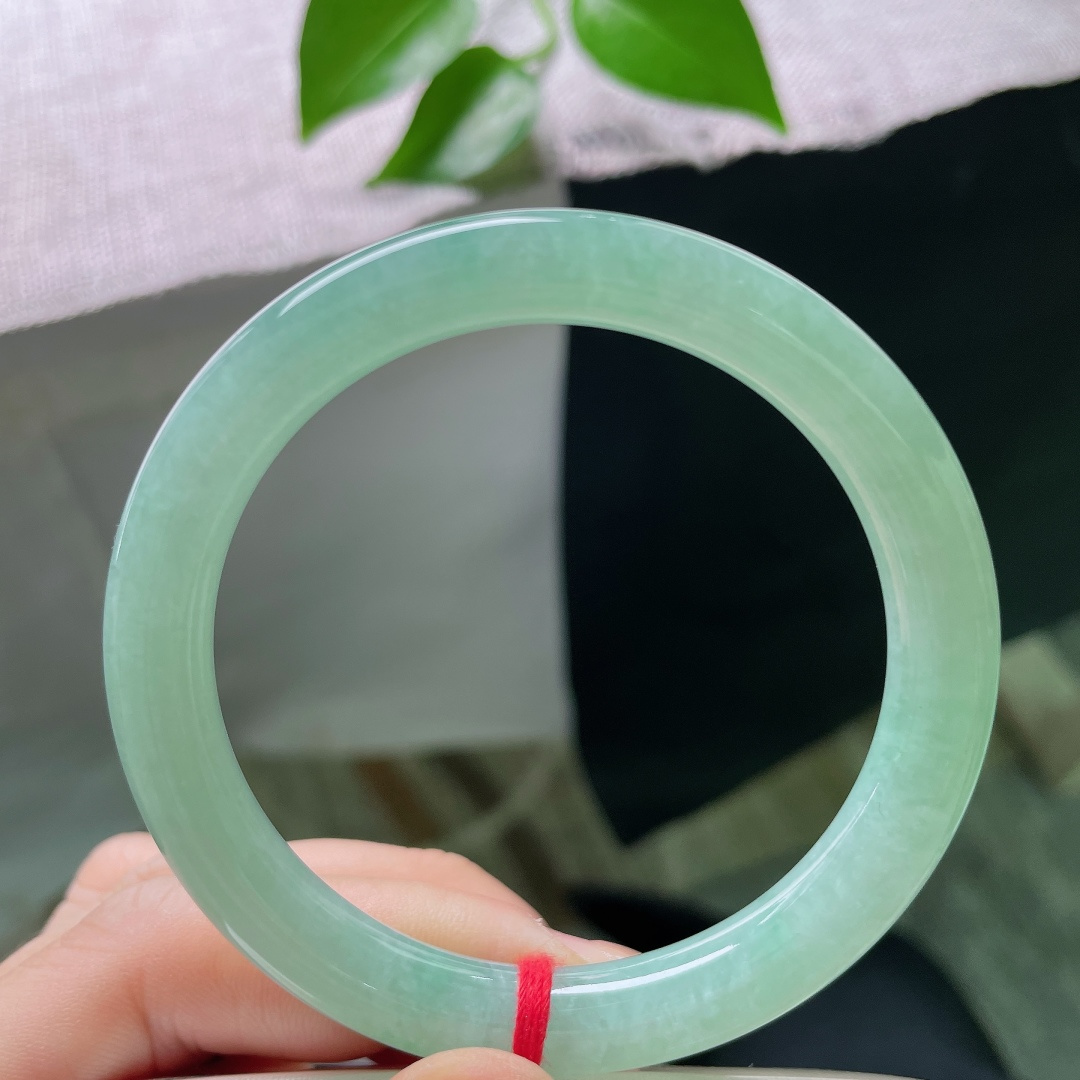 56.5/9.5，绿底圆条，无裂，圆润圆条镯身饱满敦厚，清润果绿萦绕玉间，冰感莹透，腕间漾出清新温婉古韵。ss59643a