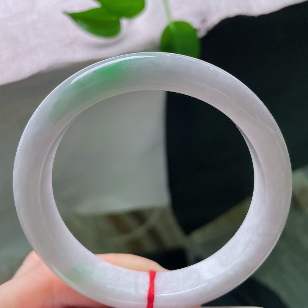 60.8/12.7/8.9，淡紫正圈，一点皮纹，素白玉地温润匀净，几抹浅绿轻轻萦绕镯壁，色调清新柔和
