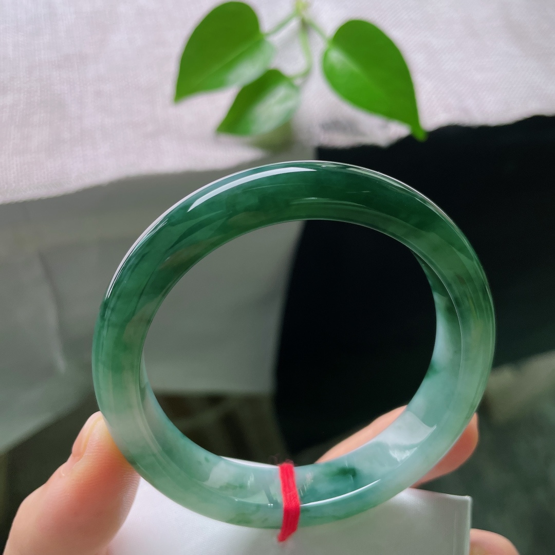 56.5/12.3/8.7，飘花正圈，小碎纹，温润水亮，细腻光滑，浓郁的墨绿飘花成片晕染在镯身，沉静中藏着生机。ss59420a