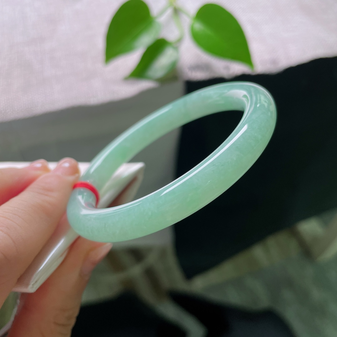 56.5/9.5，绿底圆条，无裂，圆润圆条镯身饱满敦厚，清润果绿萦绕玉间，冰感莹透，腕间漾出清新温婉古韵。ss59643a