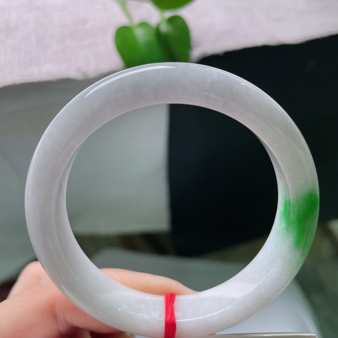 53.8/12/8.3，飘绿正圈，一点皮纹，玉质温润细腻，洁白底色干净素雅，一抹辣绿浓艳明媚，镯型端