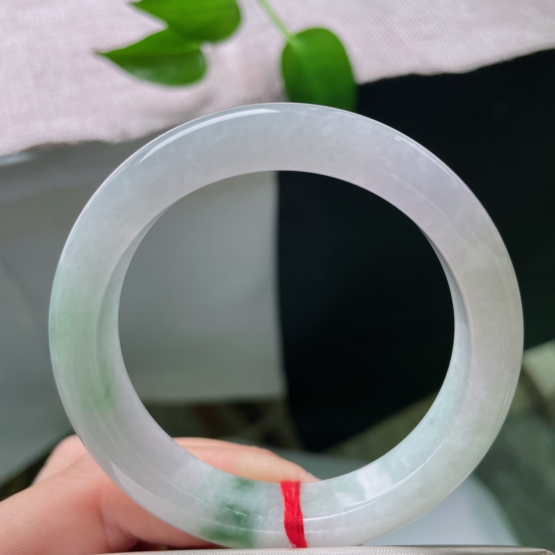 52.9/11.7/8.2，春彩正圈，晶体，冰润玉底清透干净，一抹辣绿灵动点缀镯身，翠色鲜活，简约平安镯尽显雅致东方韵味。ss59536a