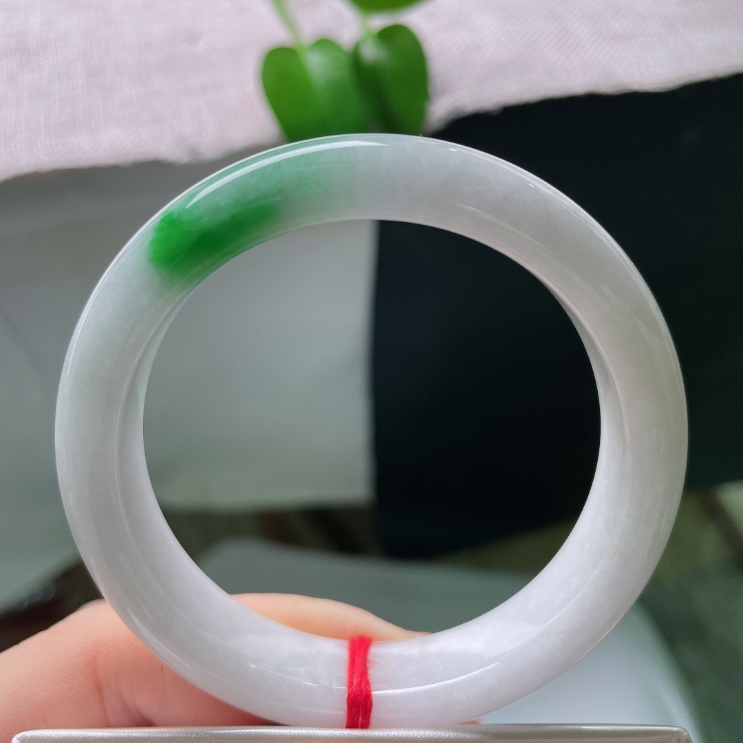 53.8/12/8.3，飘绿正圈，一点皮纹，玉质温润细腻，洁白底色干净素雅，一抹辣绿浓艳明媚，镯型端