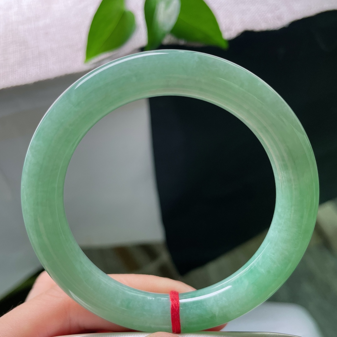 58/10.5，满色圆条，无裂，冰润湖绿，一汪清翠凝于腕间，镯身饱满浑厚，自带温婉古典气韵。ss59