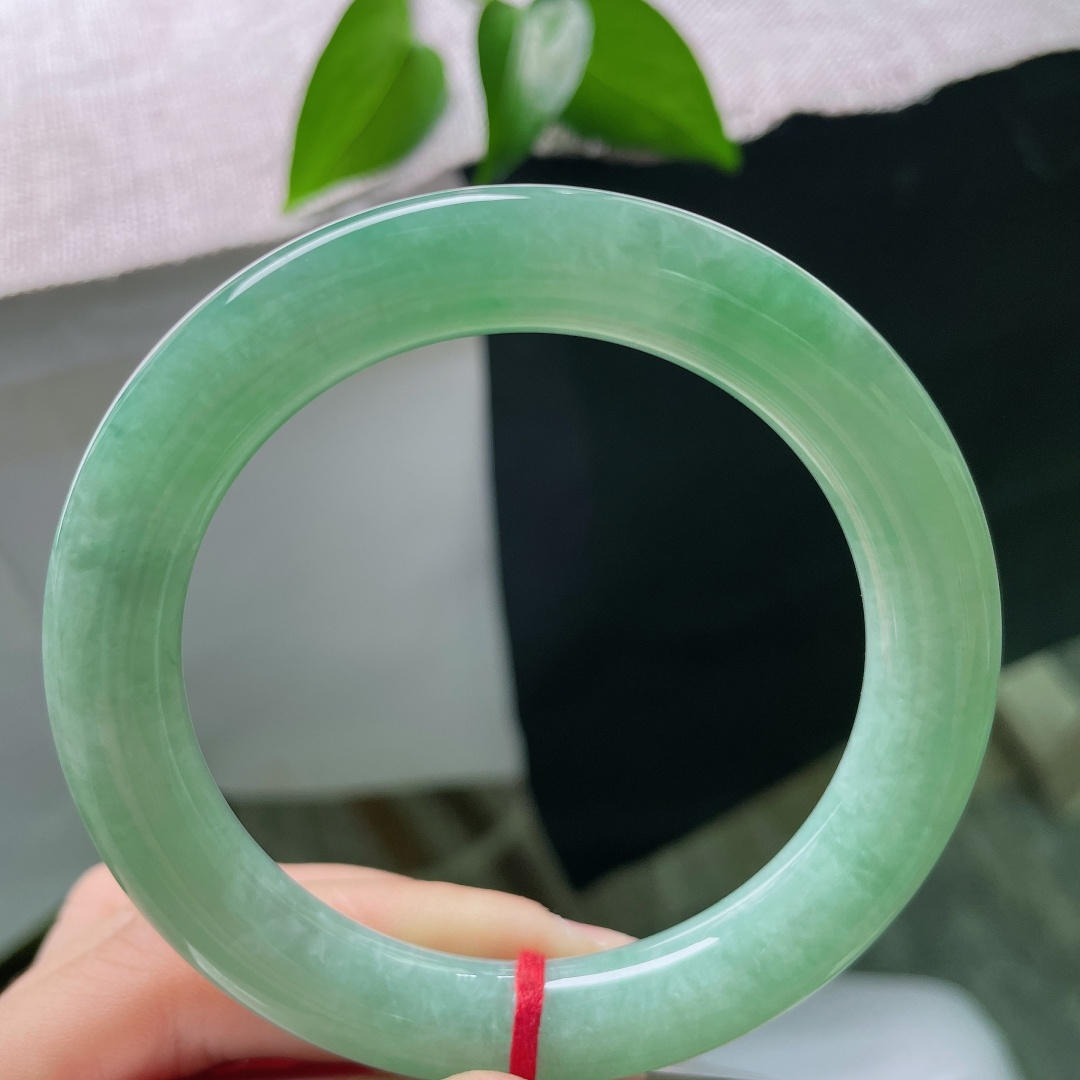 58/10.5，满色圆条，无裂，冰润湖绿，一汪清翠凝于腕间，镯身饱满浑厚，自带温婉古典气韵。ss59