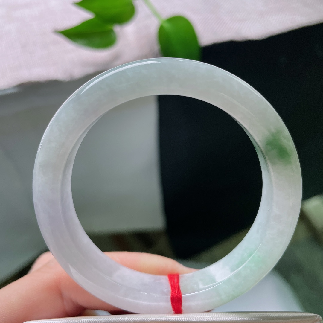 52.9/11.7/8.2，春彩正圈，晶体，冰润玉底清透干净，一抹辣绿灵动点缀镯身，翠色鲜活，简约平安镯尽显雅致东方韵味。ss59536a