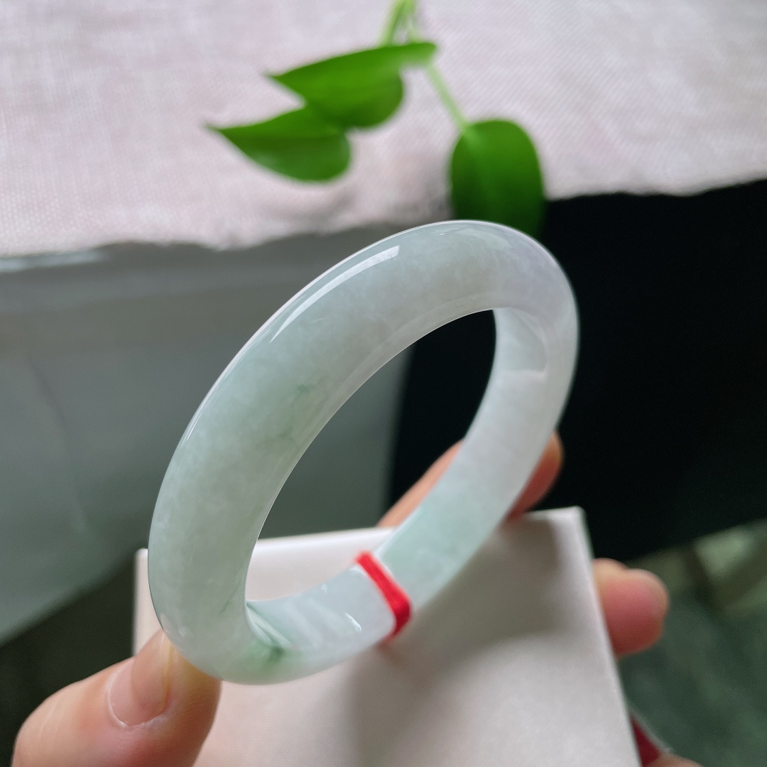 52.9/11.7/8.2，春彩正圈，晶体，冰润玉底清透干净，一抹辣绿灵动点缀镯身，翠色鲜活，简约平安镯尽显雅致东方韵味。ss59536a