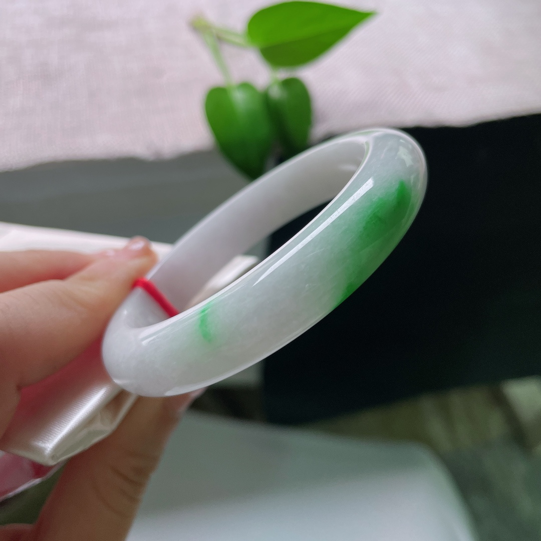53.8/12/8.3，飘绿正圈，一点皮纹，玉质温润细腻，洁白底色干净素雅，一抹辣绿浓艳明媚，镯型端庄大气。ss59654a