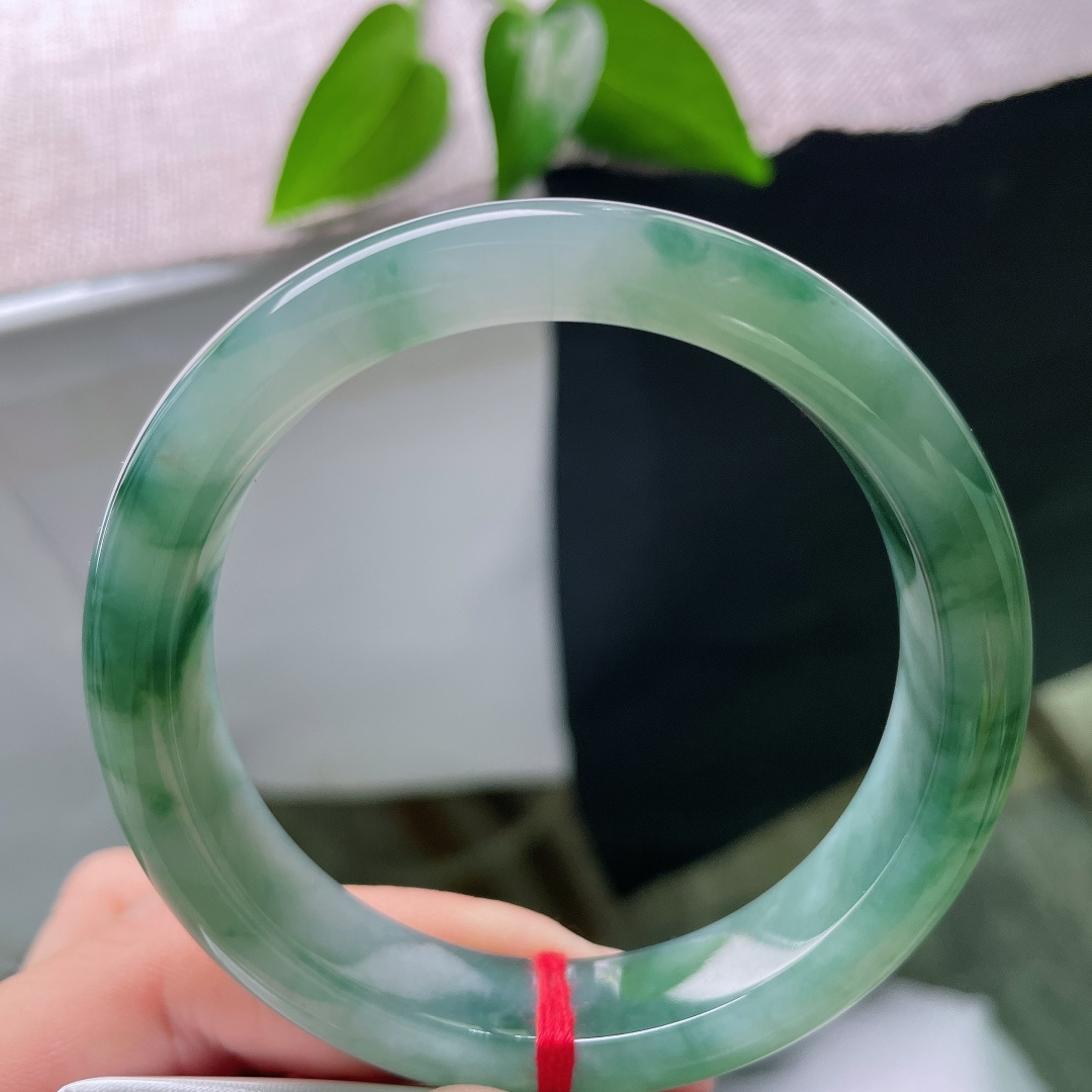 56.5/12.4/8.3，飘花正圈，无裂，冰润清透玉底，墨绿飘花如云烟漫卷镯身，水墨写意，腕间藏尽