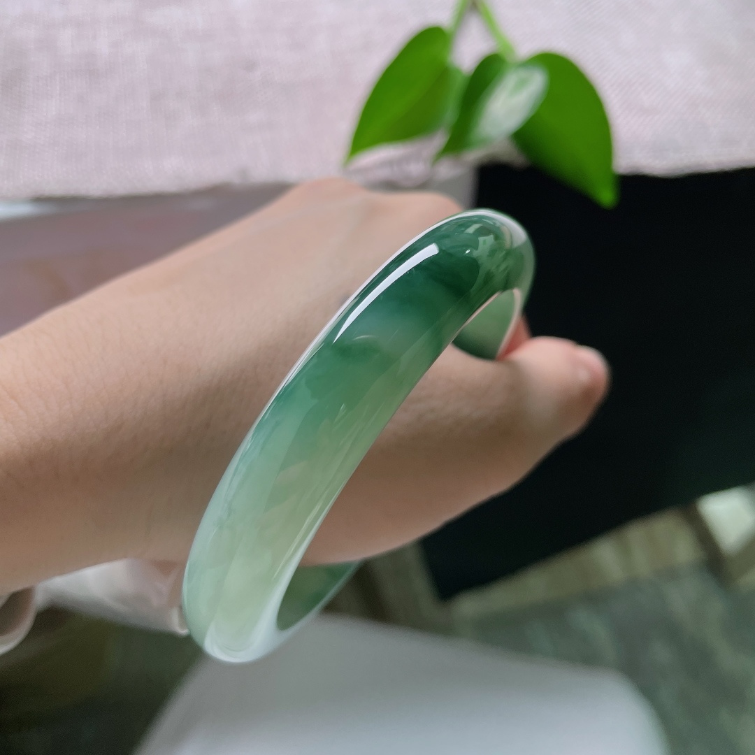 58.8/12.3/8.6，飘花正圈，无裂，冰底清润通透莹亮，墨绿飘花如水墨晕染镯身，山水意境悠悠，尽显沉静气韵。ss59423a
