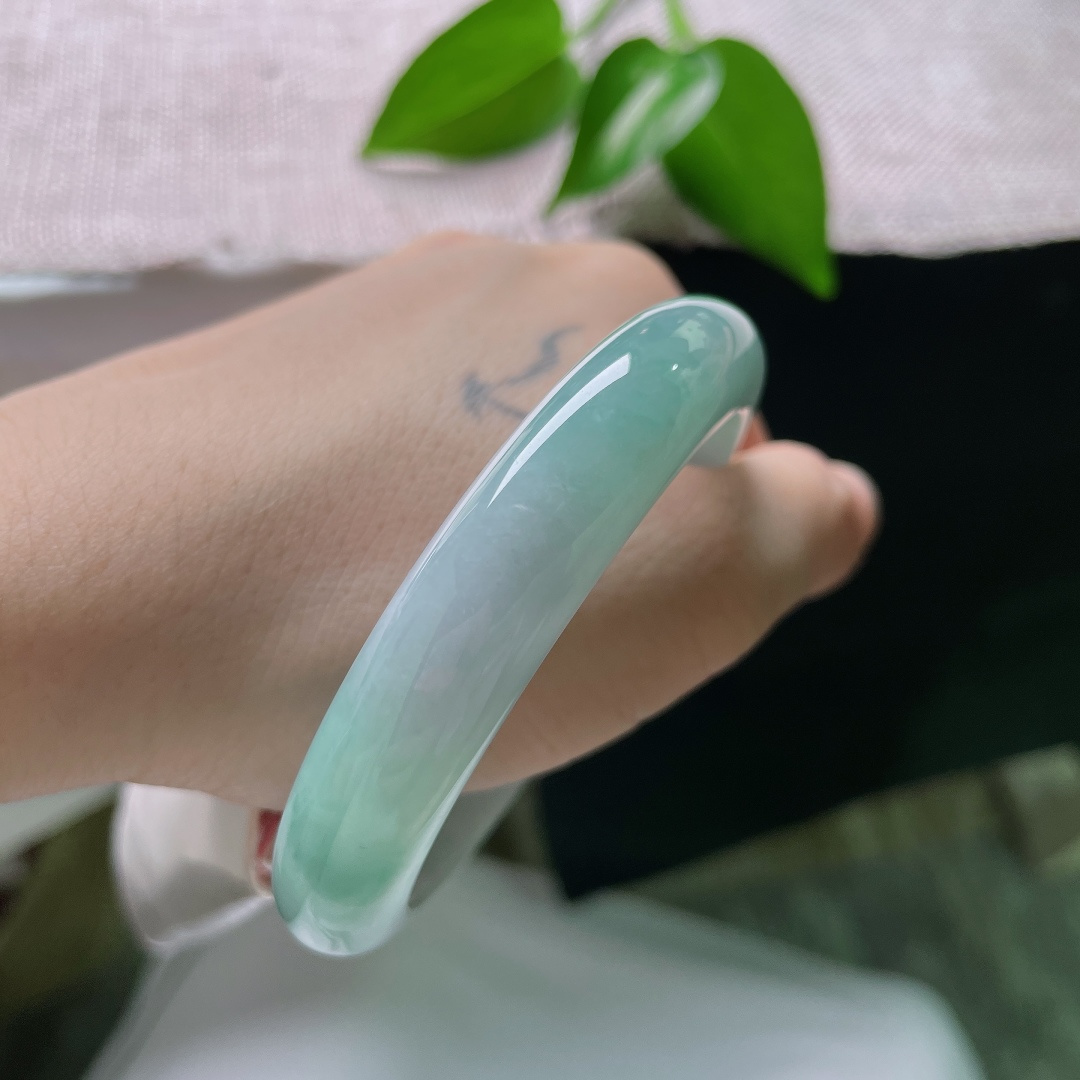 57/12/8.1，蓝底正圈，一点皮纹，冰润质地匀净莹亮，青白与翠色温柔相接，素面玉镯不加雕琢，自带沉静温润质感。ss59286a