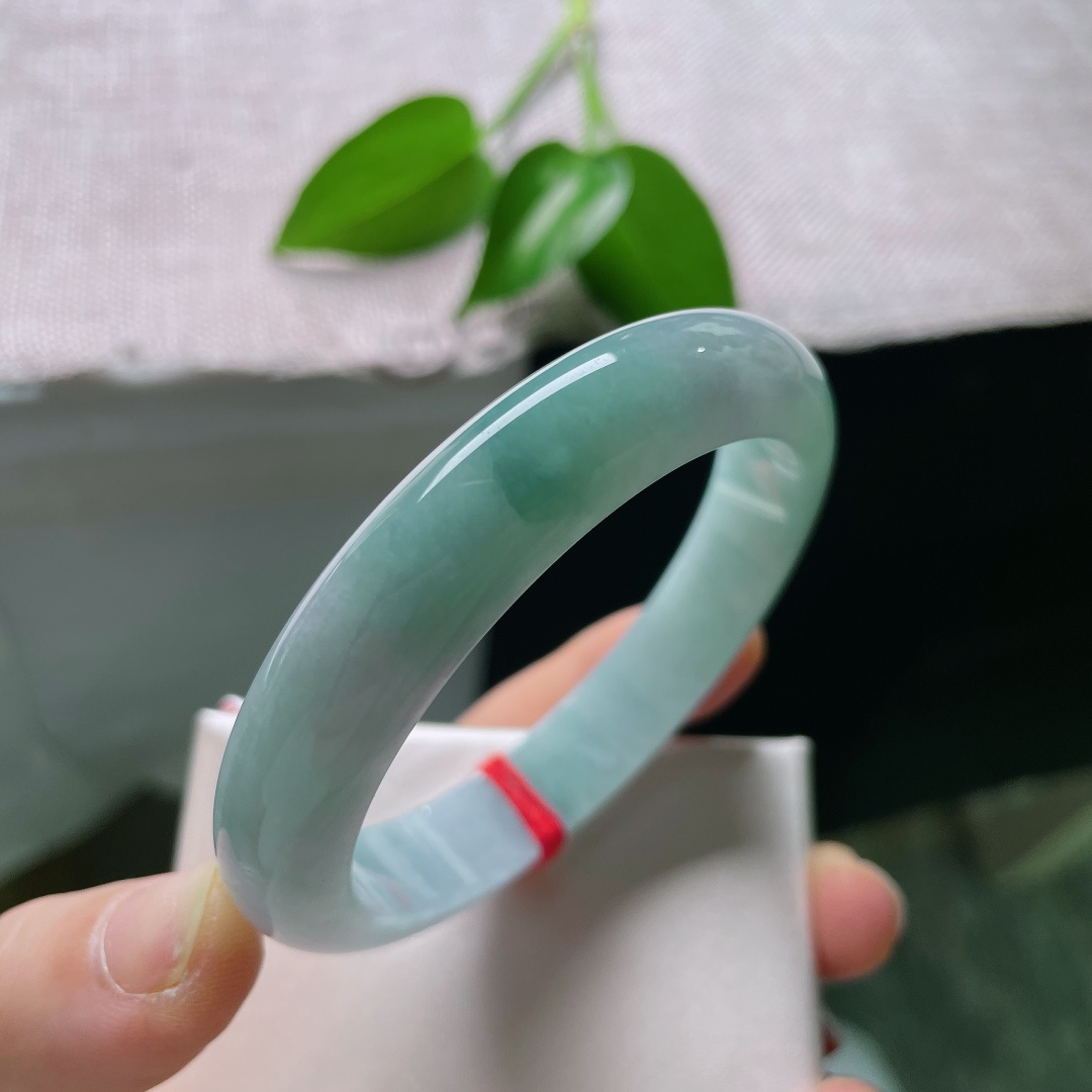 57/12/8.1，蓝底正圈，一点皮纹，冰润质地匀净莹亮，青白与翠色温柔相接，素面玉镯不加雕琢，自带沉静温润质感。ss59286a