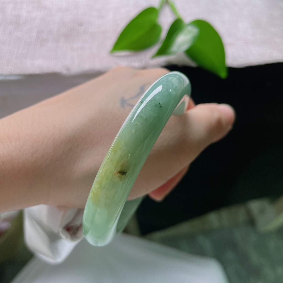 56.7/11.8/9.0，绿底正圈，一点皮纹，冰润油青底色沉静柔和，一抹黄翡温婉晕染，平安镯古韵悠然，腕间藏尽山河诗意。ss59676a