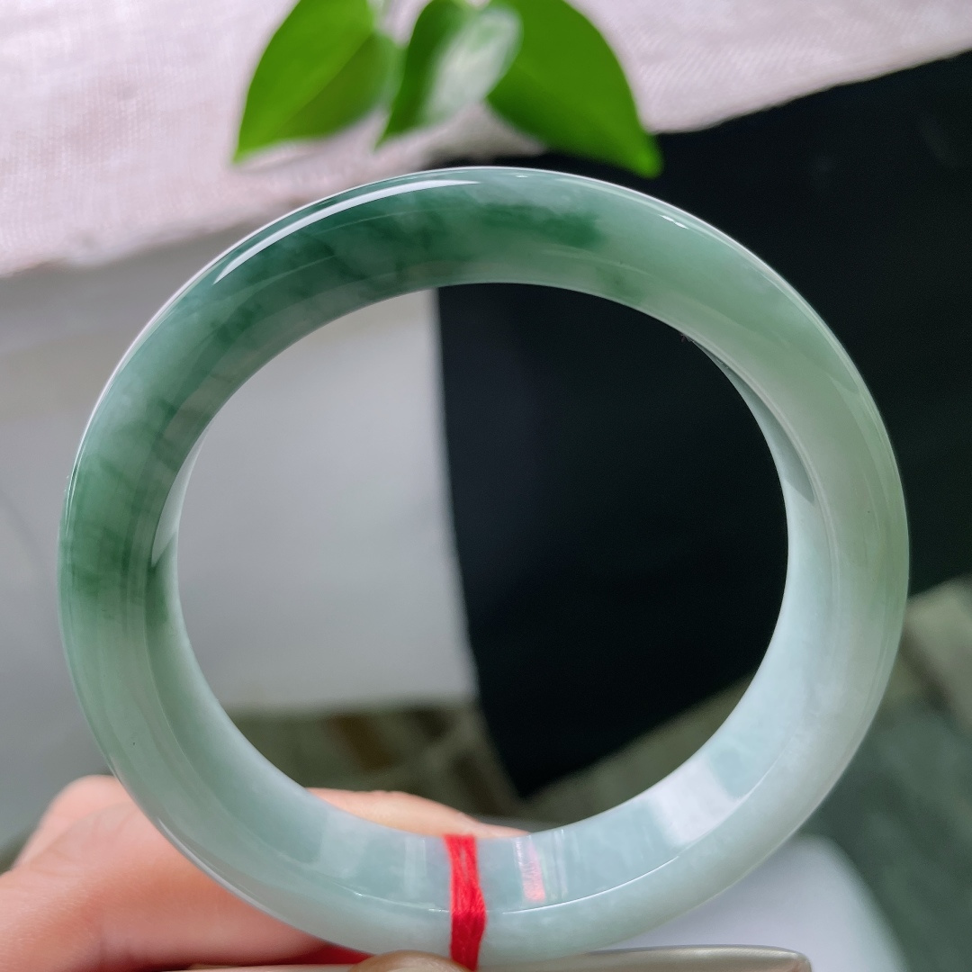 57.3/12.3/8.4，飘花正圈，无裂，幽蓝玉底承袅袅墨花，种水头充盈透亮，端庄素圈，沉淀淡然清