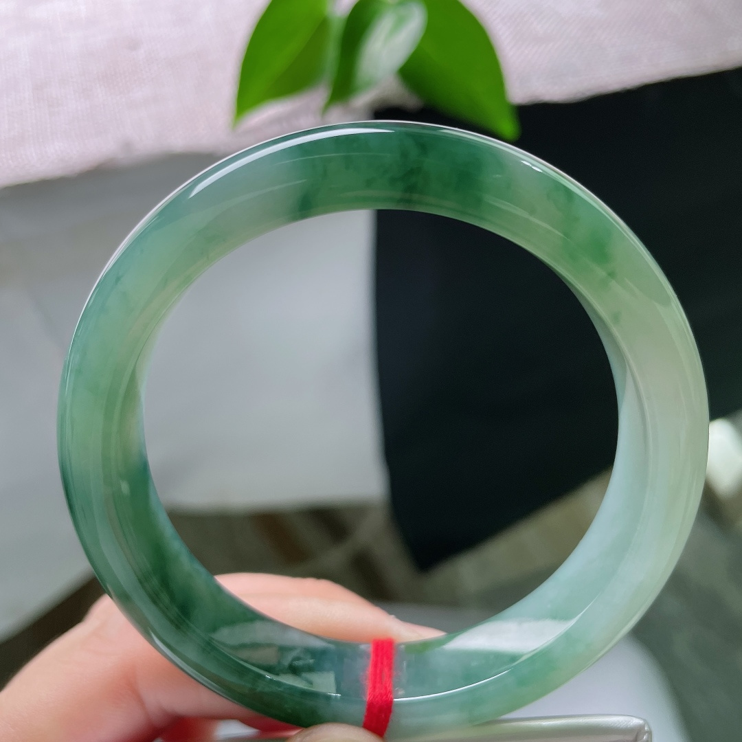 58.8/12.3/8.6，飘花正圈，无裂，冰底清润通透莹亮，墨绿飘花如水墨晕染镯身，山水意境悠悠，尽显沉静气韵。ss59423a