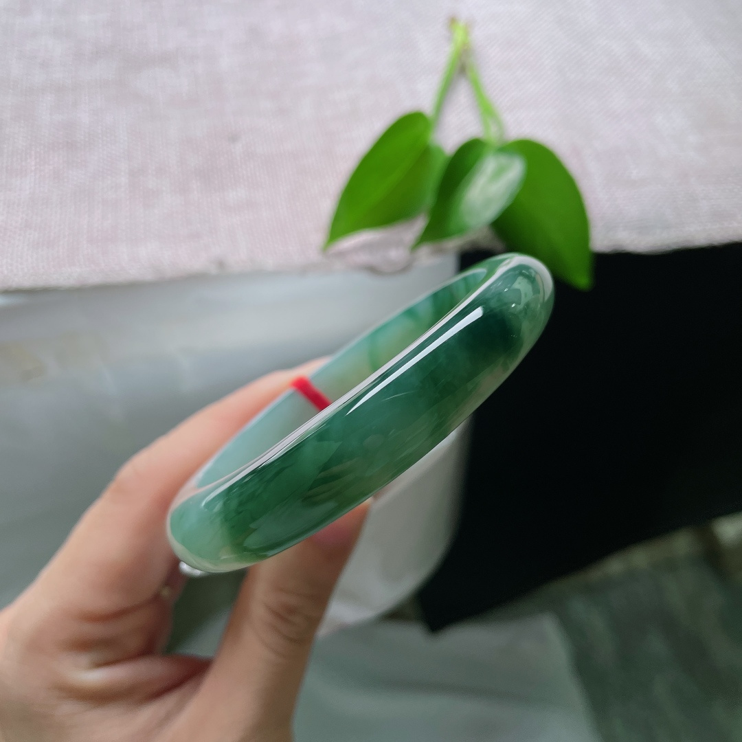 58.8/12.3/8.6，飘花正圈，无裂，冰底清润通透莹亮，墨绿飘花如水墨晕染镯身，山水意境悠悠，尽显沉静气韵。ss59423a