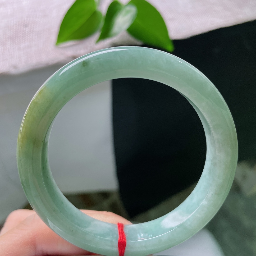 56.7/11.8/9.0，绿底正圈，一点皮纹，冰润油青底色沉静柔和，一抹黄翡温婉晕染，平安镯古韵悠然，腕间藏尽山河诗意。ss59676a
