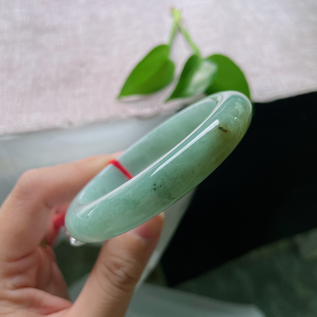 56.7/11.8/9.0，绿底正圈，一点皮纹，冰润油青底色沉静柔和，一抹黄翡温婉晕染，平安镯古韵悠然，腕间藏尽山河诗意。ss59676a