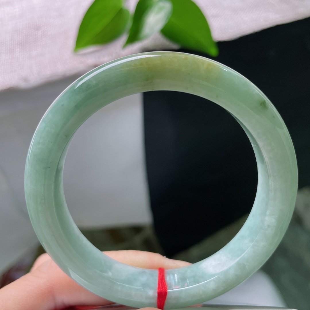 56.7/11.8/9.0，绿底正圈，一点皮纹，冰润油青底色沉静柔和，一抹黄翡温婉晕染，平安镯古韵悠
