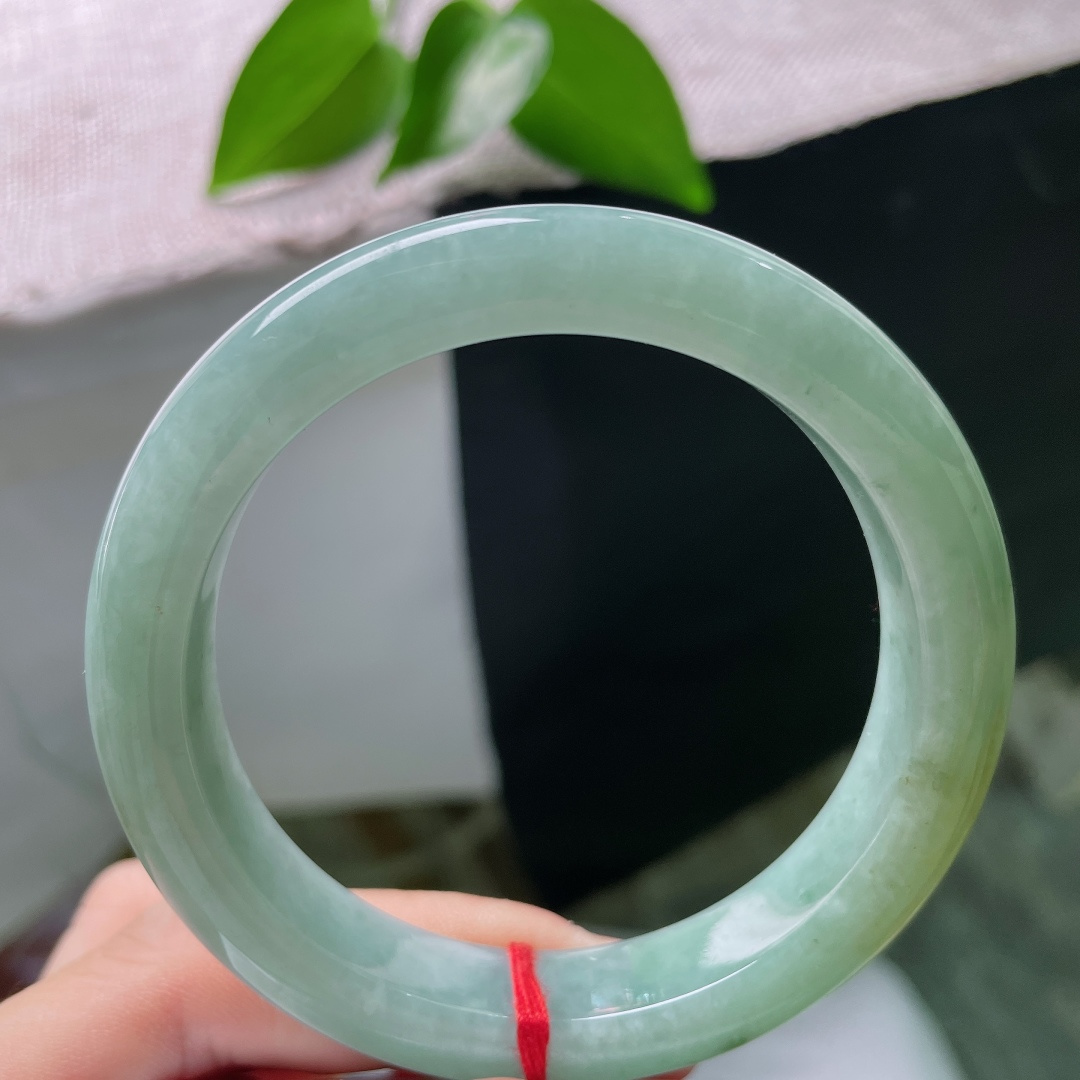 56.7/11.8/9.0，绿底正圈，一点皮纹，冰润油青底色沉静柔和，一抹黄翡温婉晕染，平安镯古韵悠然，腕间藏尽山河诗意。ss59676a