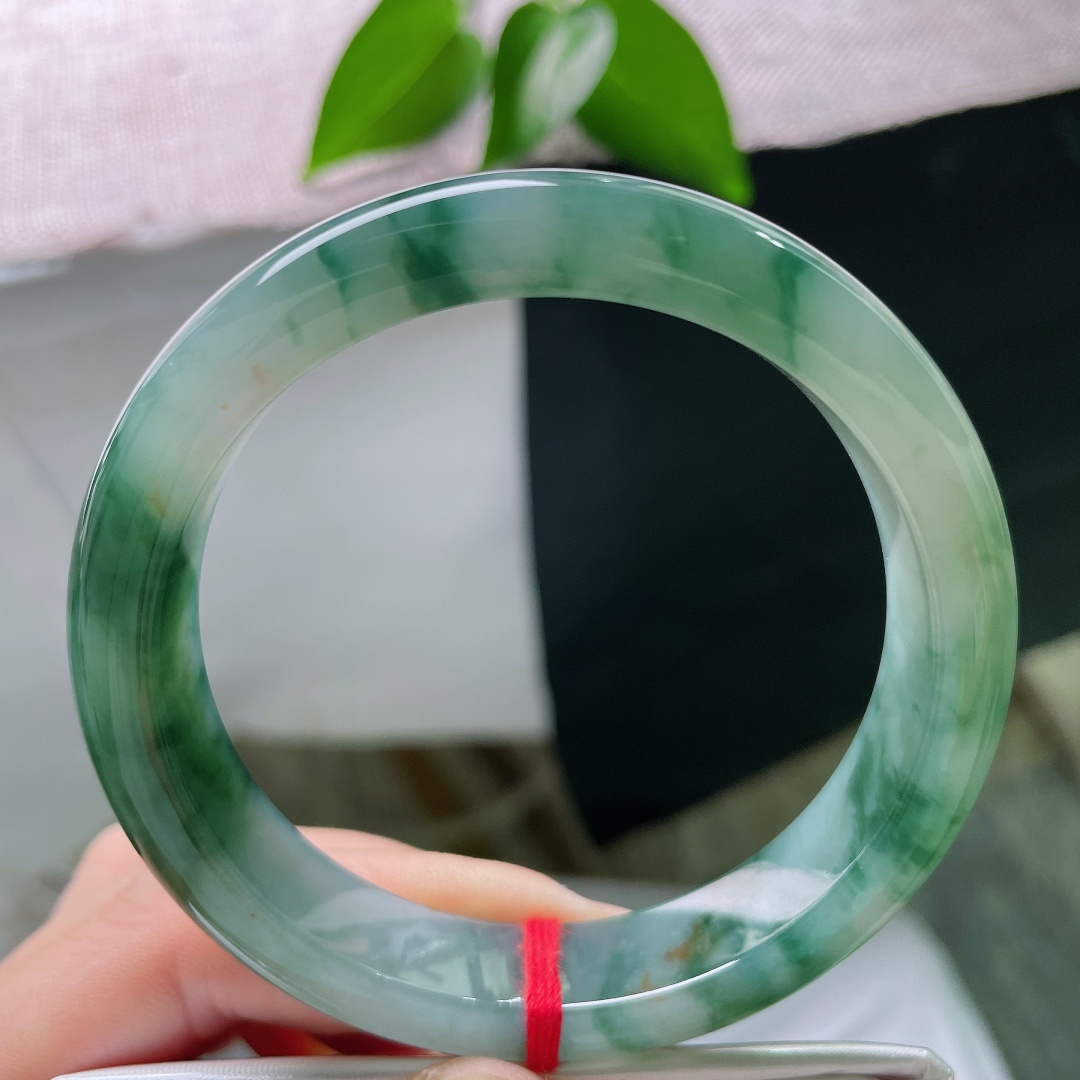 58.2/12.1/8.6，飘花正圈，无裂，洒金，冰种玉质细腻匀净，浓墨绿意缥缈漫洒玉璧，端庄正圈，