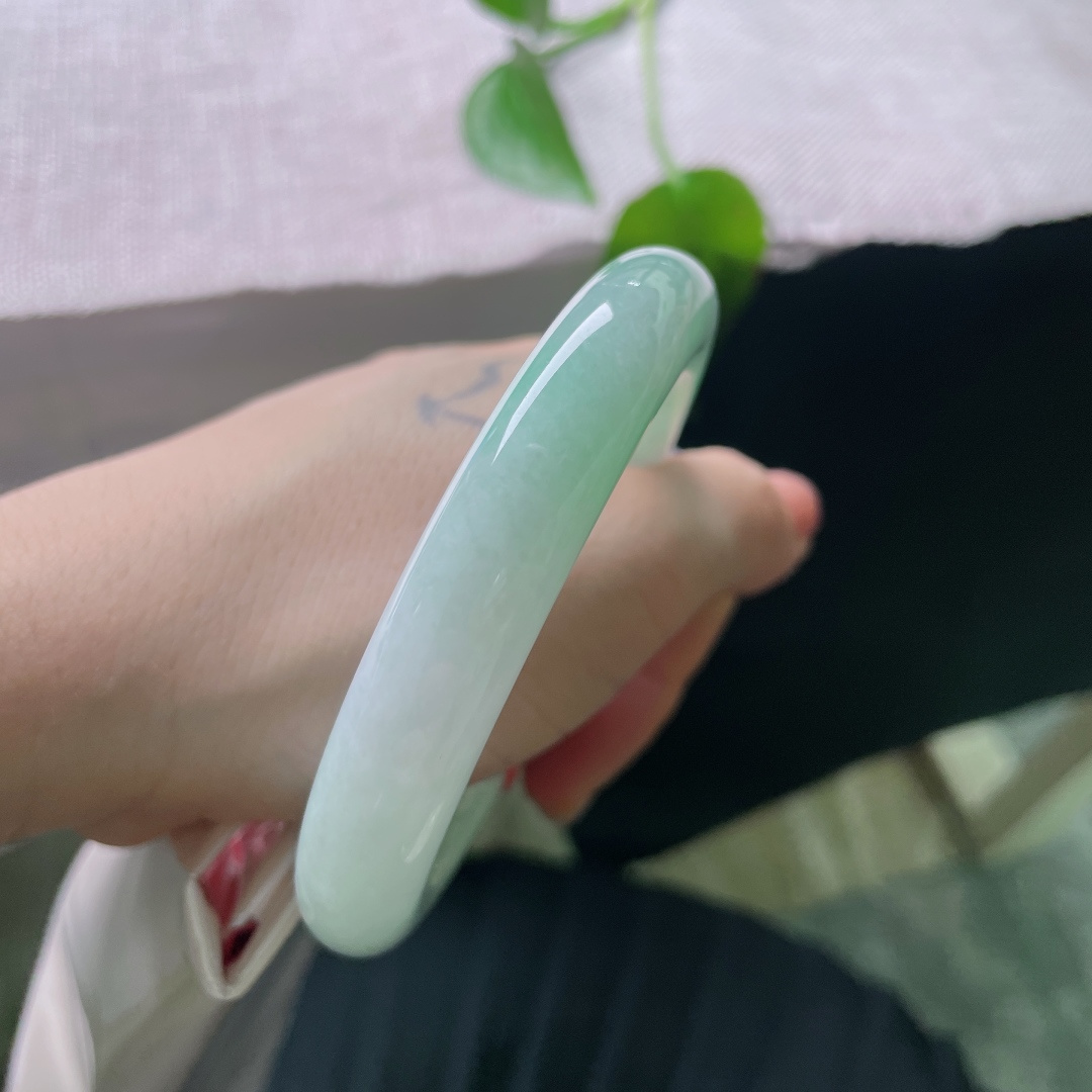 56/11.9，飘绿圆条，无裂，饱满圆条镯型，玉质温润莹白，几抹阳绿随性晕染，不聚不散，于素净底色之上，漾开点点生机。ss56686a