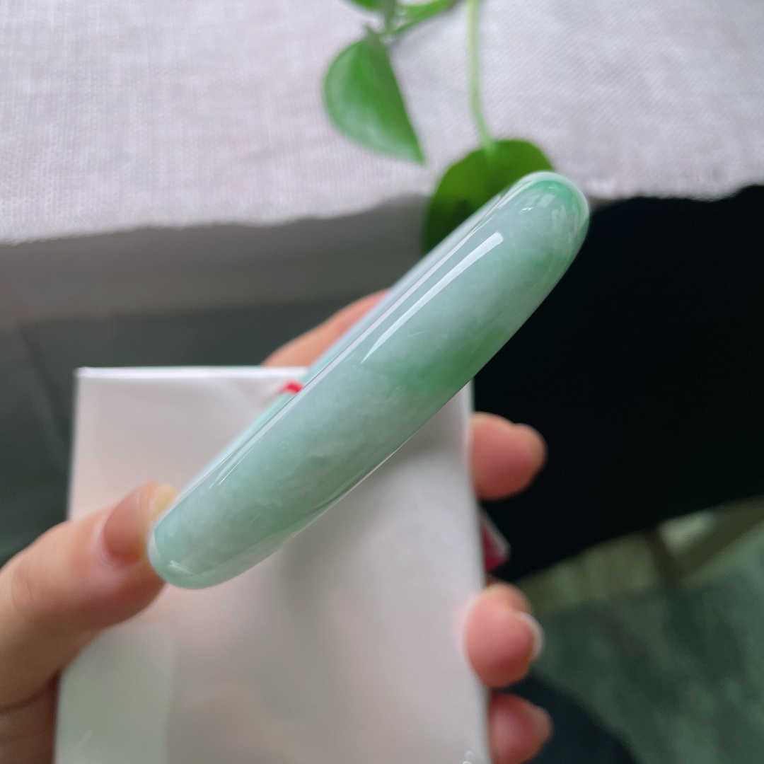 56/11.9，飘绿圆条，无裂，饱满圆条镯型，玉质温润莹白，几抹阳绿随性晕染，不聚不散，于素净底色之上，漾开点点生机。ss56686a
