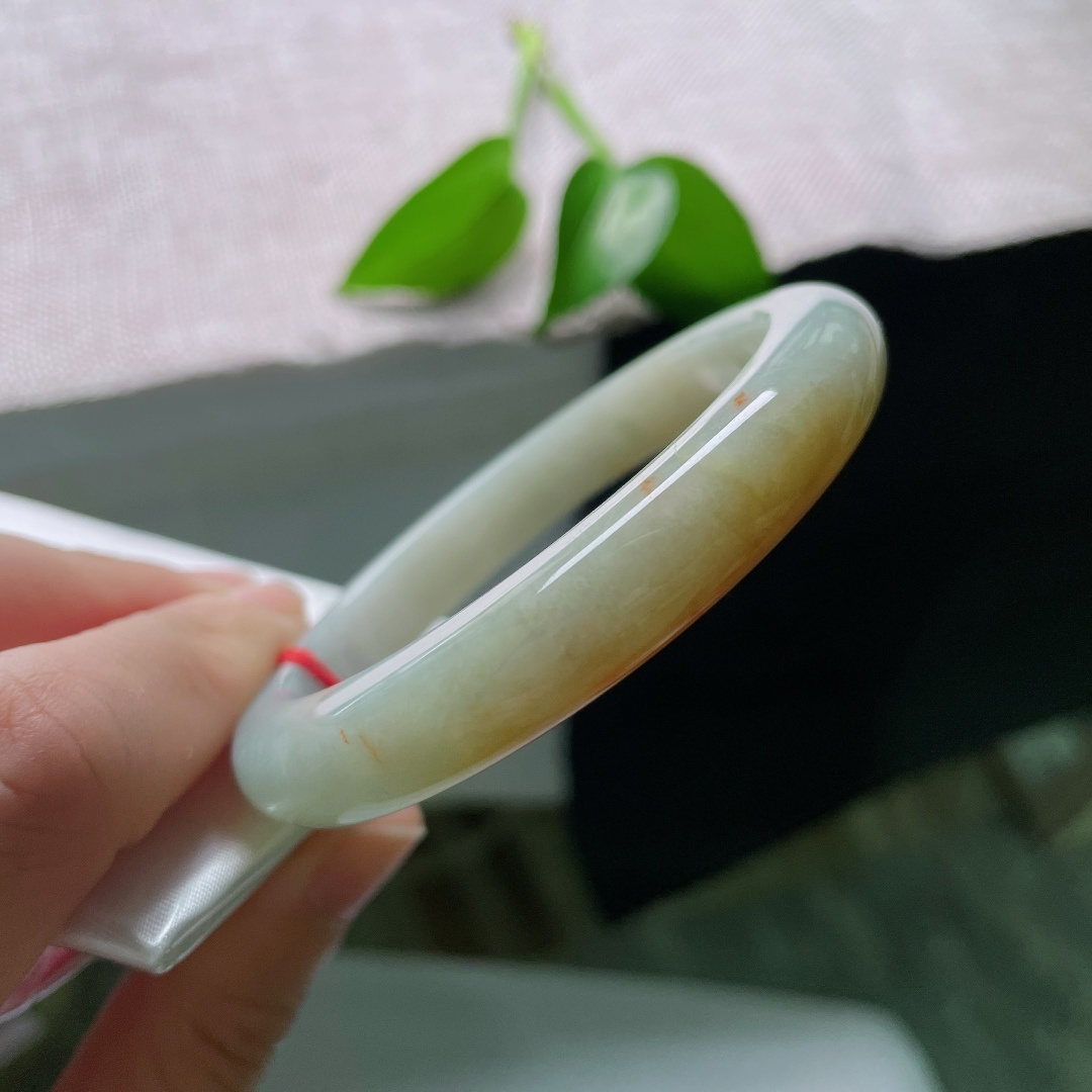 56.8/10.6/8.5，黄翡正圈，一点皮纹，温润玉底清透柔和，一抹金黄缱绻萦绕镯身，金秋诗意流转，尽显复古雅致国风韵味。ss59657a
