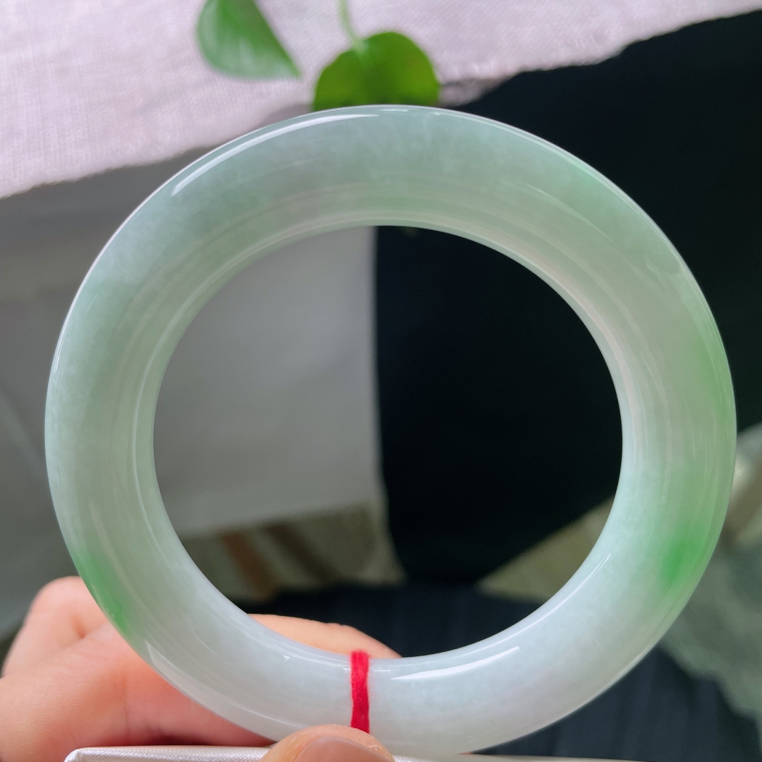 56/11.9，飘绿圆条，无裂，饱满圆条镯型，玉质温润莹白，几抹阳绿随性晕染，不聚不散，于素净底色之上，漾开点点生机。ss56686a