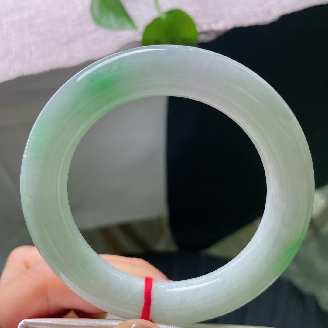 56/11.9，飘绿圆条，无裂，饱满圆条镯型，玉质温润莹白，几抹阳绿随性晕染，不聚不散，于素净底色之上，漾开点点生机。ss56686a