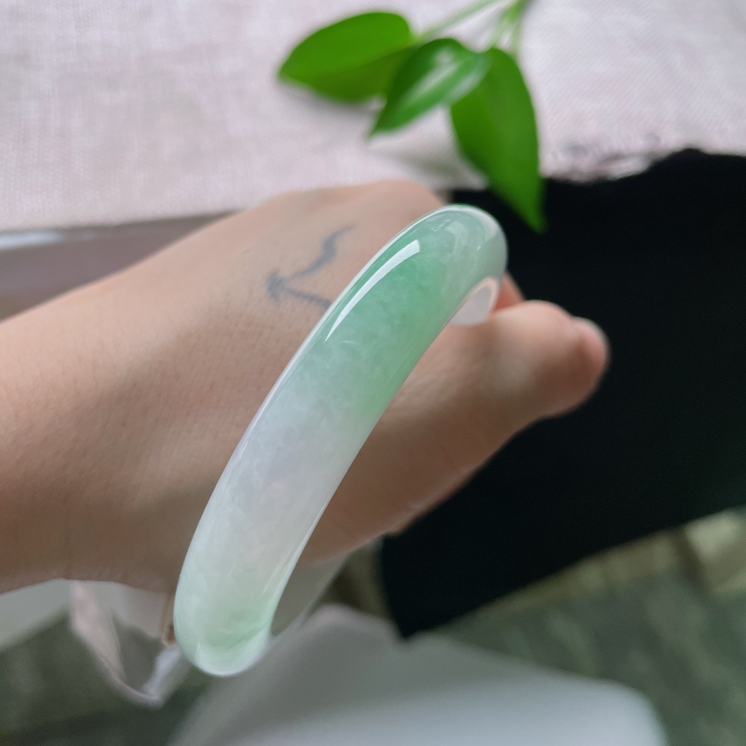 55/11/9，飘绿正圈，一点皮纹，玉以清润浅白为底，一抹鲜翠悠然落于镯身，似将春日林间的一缕青绿凝藏在玉石之中ss59545a
