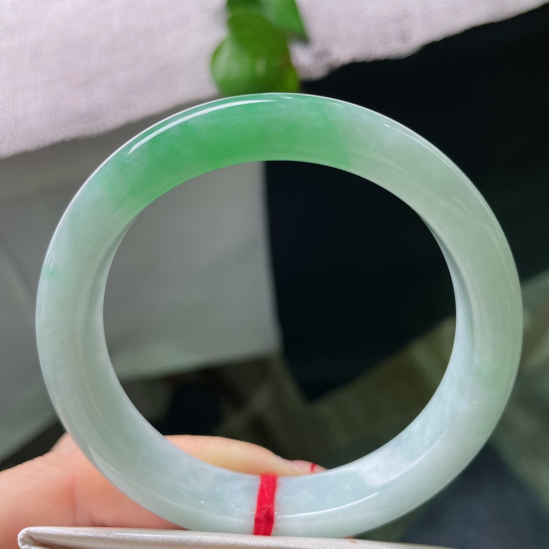 57.4/11.7/8.5，飘绿正圈，皮纹，大片鲜翠绿意铺满镯身，鲜亮翠色衬得玉底清润灵动。ss58