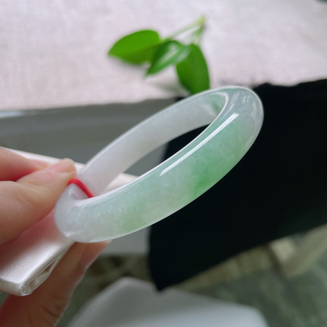 55/11/9，飘绿正圈，一点皮纹，玉以清润浅白为底，一抹鲜翠悠然落于镯身，似将春日林间的一缕青绿凝藏在玉石之中ss59545a
