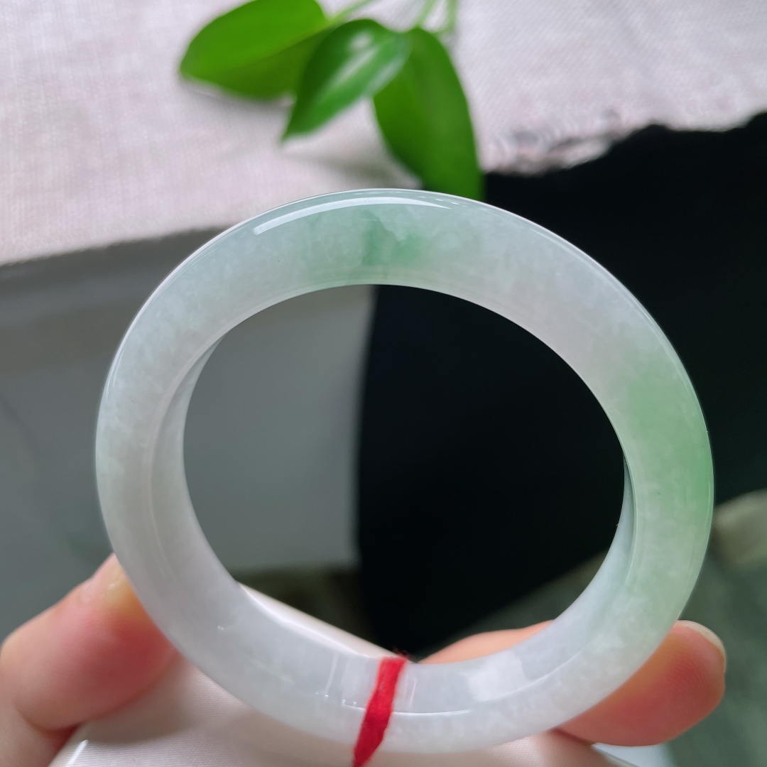 55/11/9，飘绿正圈，一点皮纹，玉以清润浅白为底，一抹鲜翠悠然落于镯身，似将春日林间的一缕青绿凝藏在玉石之中ss59545a