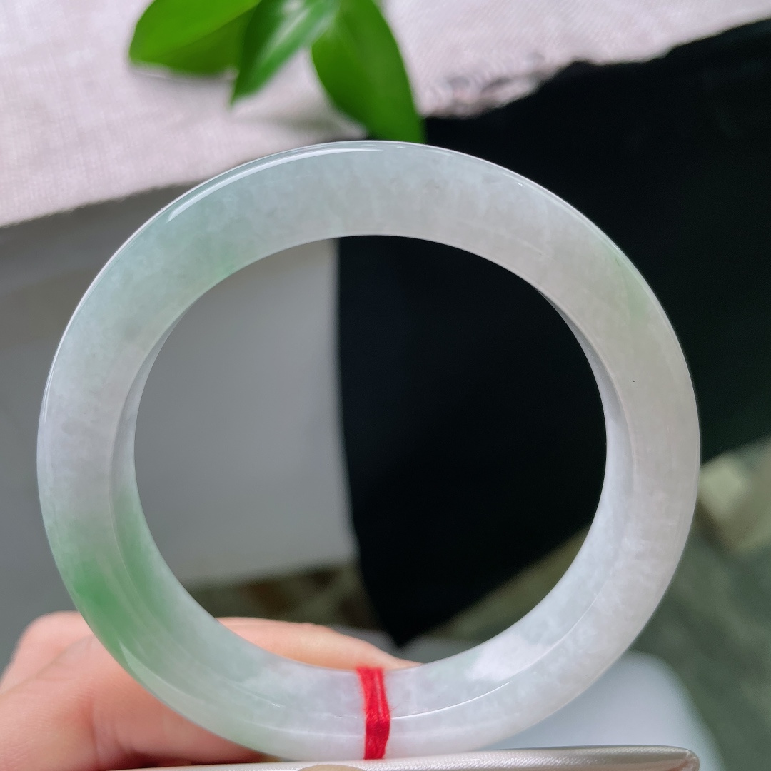 55/11/9，飘绿正圈，一点皮纹，玉以清润浅白为底，一抹鲜翠悠然落于镯身，似将春日林间的一缕青绿凝藏在玉石之中ss59545a