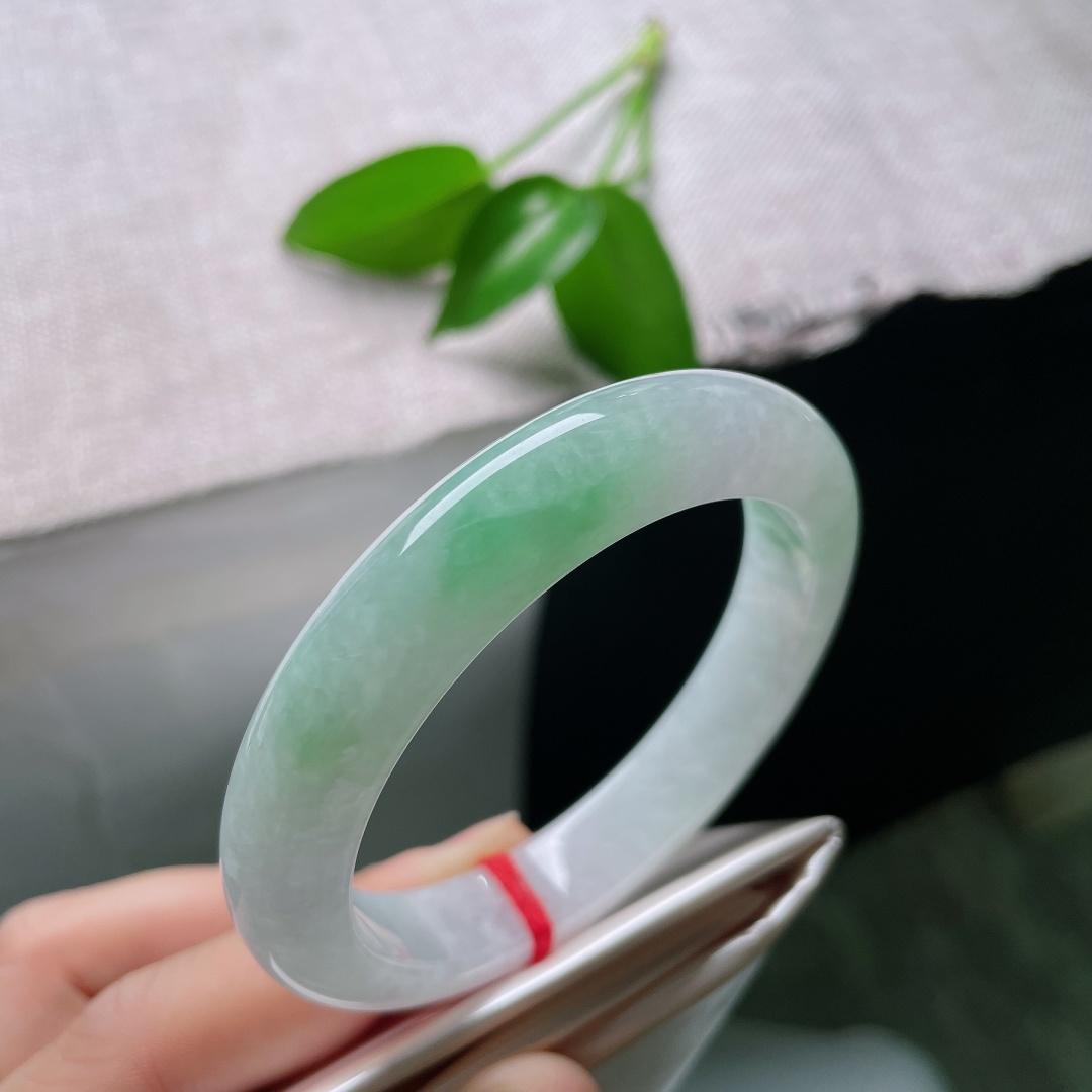 55/11/9，飘绿正圈，一点皮纹，玉以清润浅白为底，一抹鲜翠悠然落于镯身，似将春日林间的一缕青绿凝藏在玉石之中ss59545a