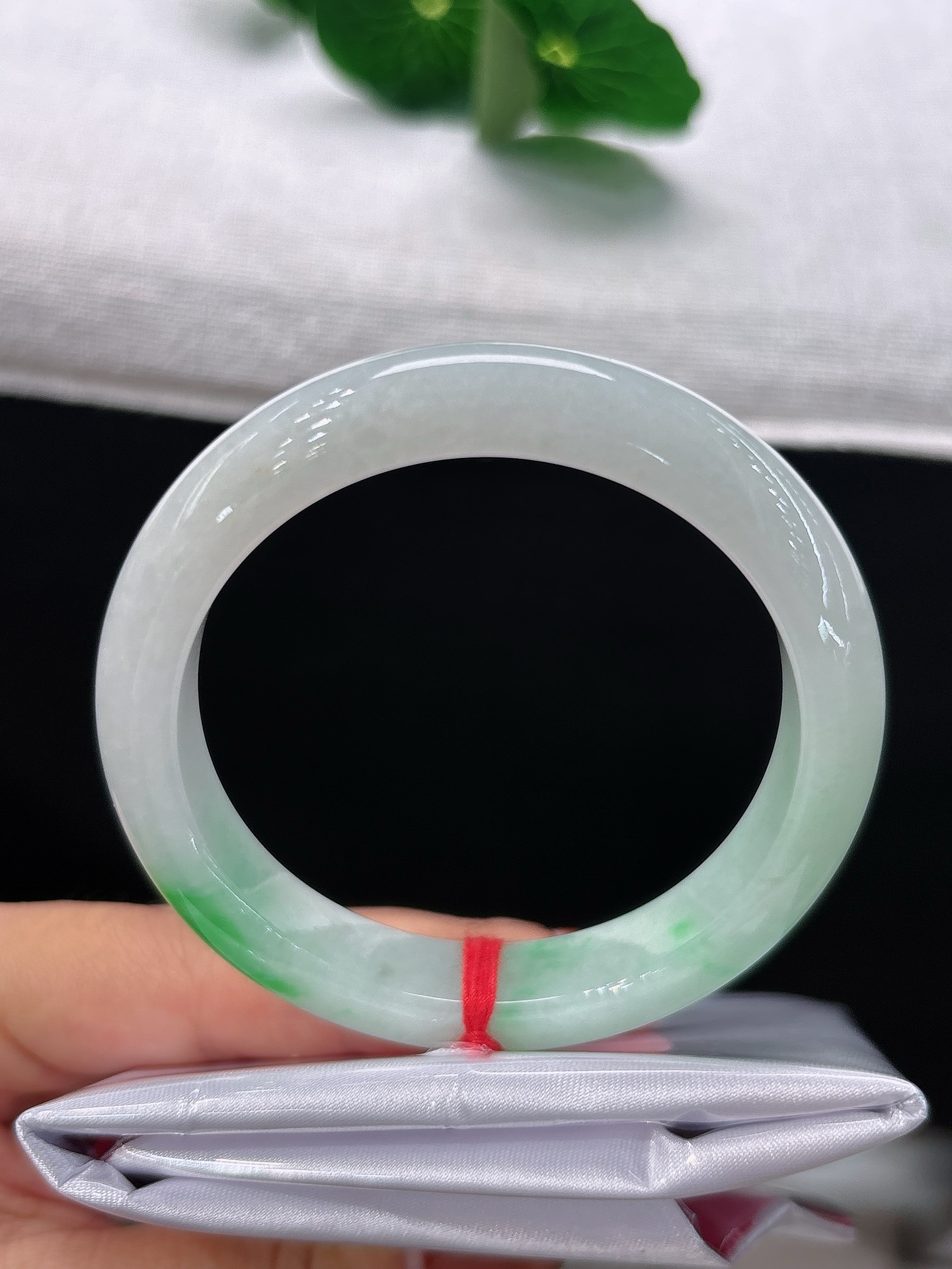 天然翡翠手镯，圈口53/10.6/8.2，正圈素白底缀一抹艳绿，恰似翠影落雪，温润明艳，雅致动人，无裂