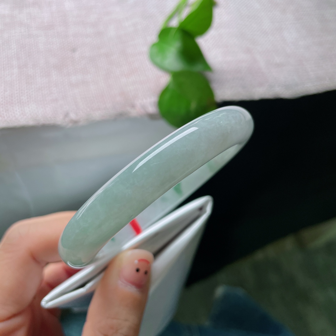 57.7/11.2/9.2，飘花正圈，无裂，冰底凝翠，柔光漫过素玉圆镯，零星绿丝随性晕开，将一池清潭绿意收于腕间，清淡含蓄，藏着独属于玉石的温柔诗意。ss57532a