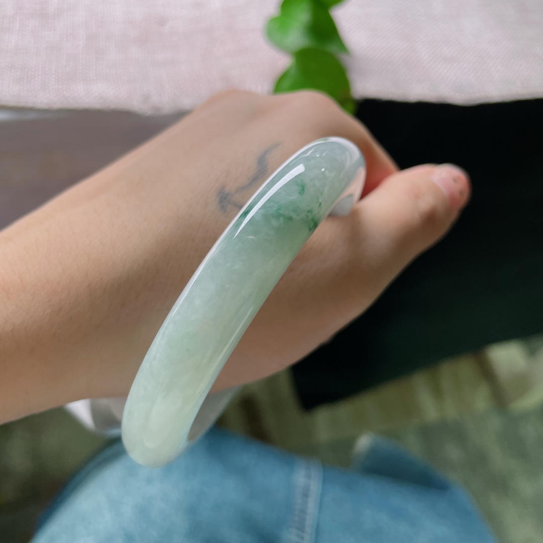 57.7/11.2/9.2，飘花正圈，无裂，冰底凝翠，柔光漫过素玉圆镯，零星绿丝随性晕开，将一池清潭绿意收于腕间，清淡含蓄，藏着独属于玉石的温柔诗意。ss57532a