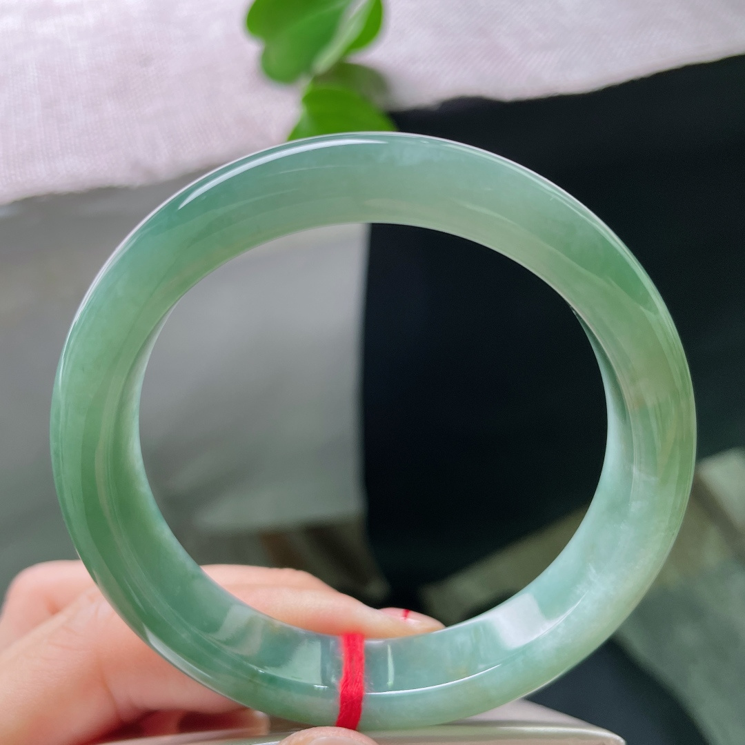 57/11.9/8.4，湖水绿飘黄翡正圈，一汪匀净湖青凝于宽厚玉镯，细腻柔光流转，素面简约尽显温润大气。ss54408a