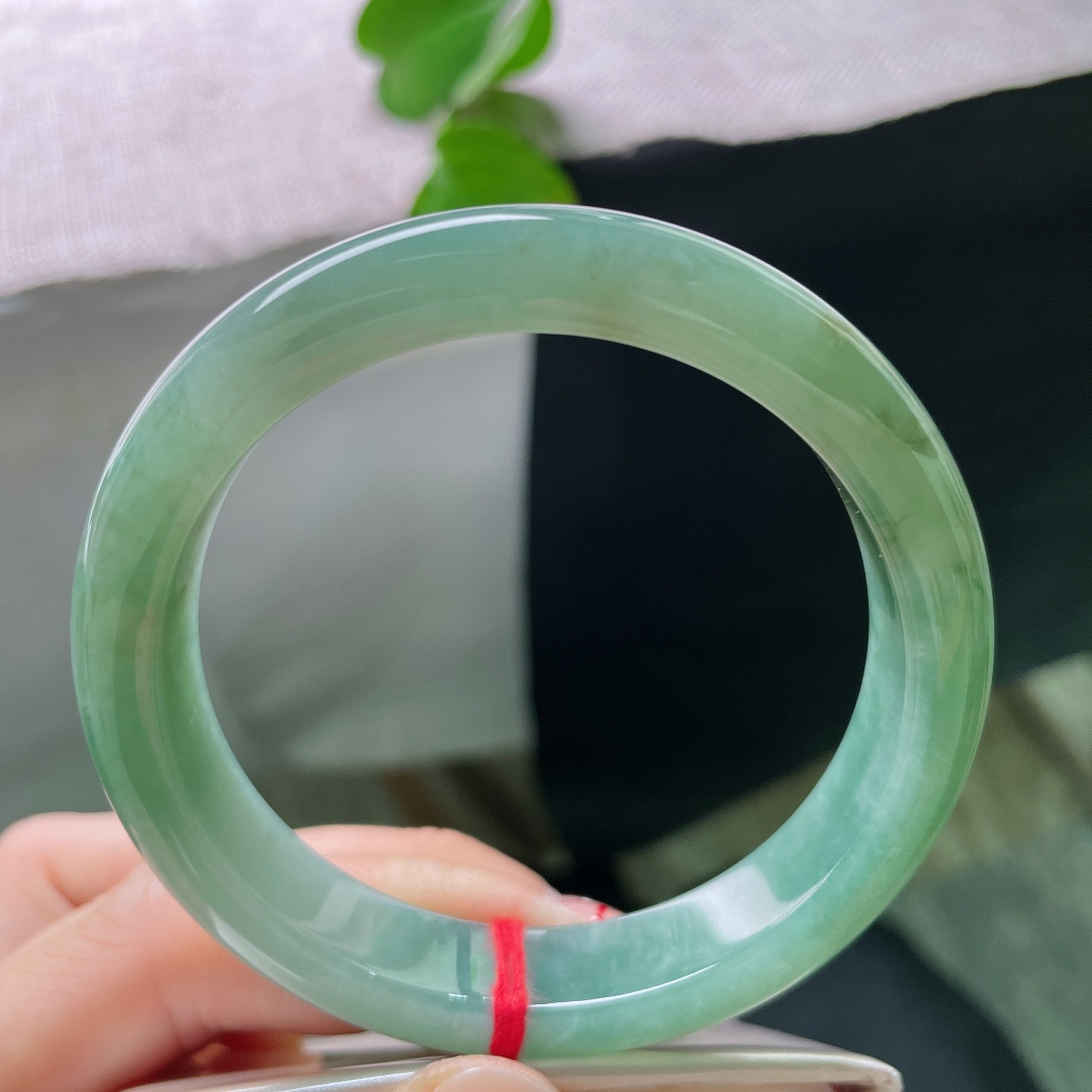 57/11.9/8.4，湖水绿飘黄翡正圈，一汪匀净湖青凝于宽厚玉镯，细腻柔光流转，素面简约尽显温润大