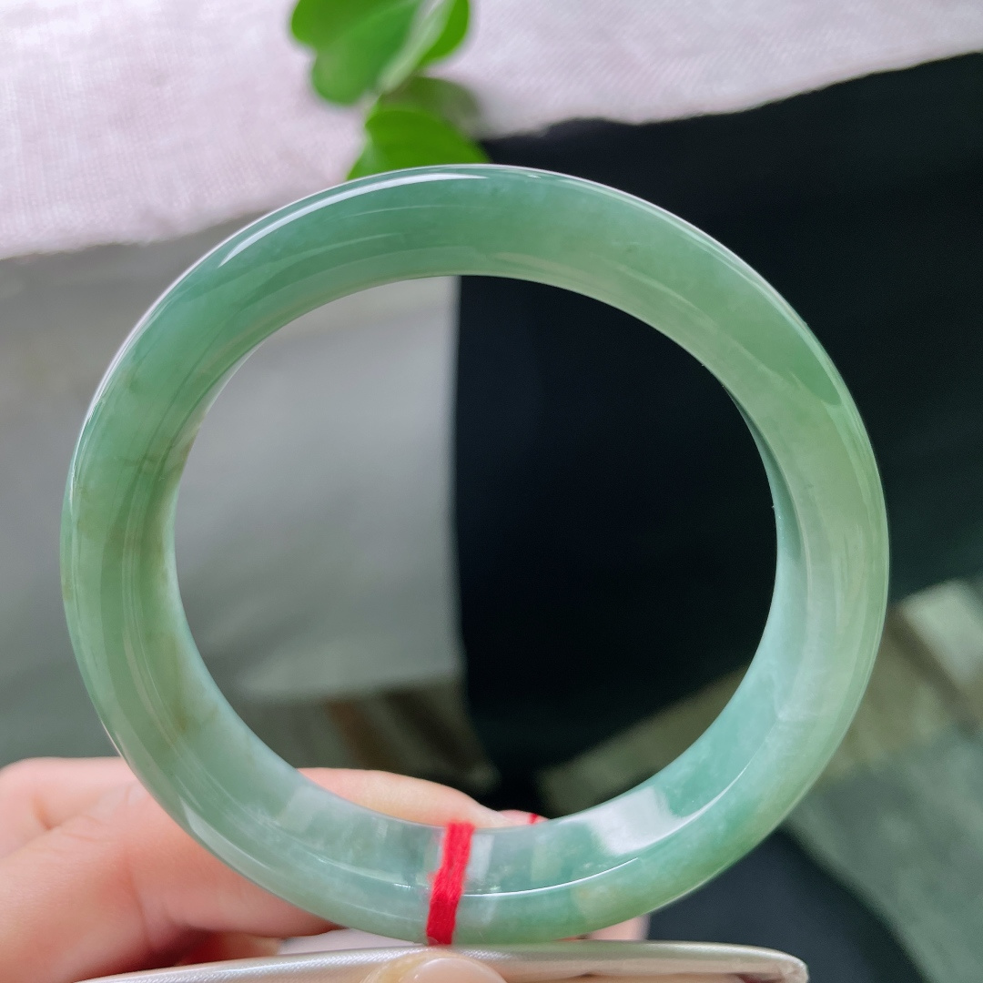 57/11.9/8.4，湖水绿飘黄翡正圈，一汪匀净湖青凝于宽厚玉镯，细腻柔光流转，素面简约尽显温润大