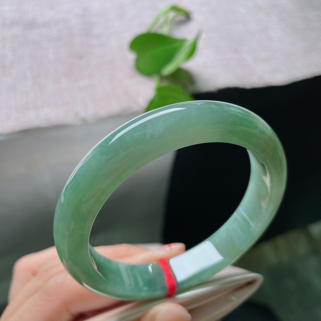 57/11.9/8.4，湖水绿飘黄翡正圈，一汪匀净湖青凝于宽厚玉镯，细腻柔光流转，素面简约尽显温润大气。ss54408a