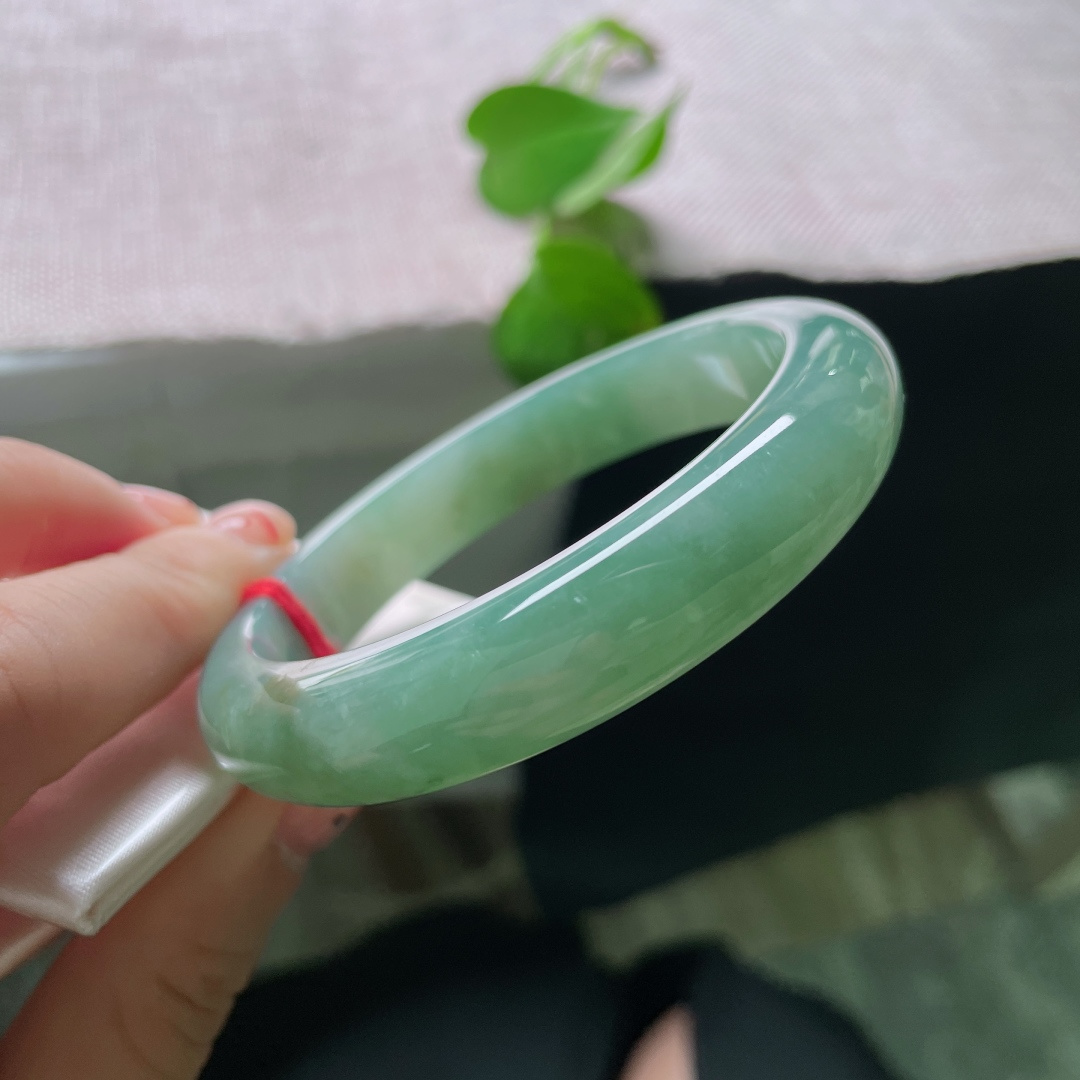 57/11.9/8.4，湖水绿飘黄翡正圈，一汪匀净湖青凝于宽厚玉镯，细腻柔光流转，素面简约尽显温润大气。ss54408a