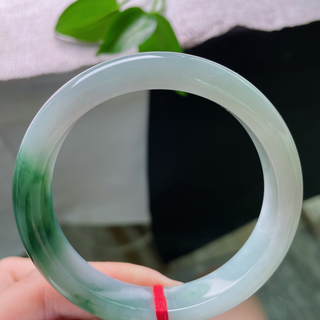 59.3/12.4/8.5，飘花正圈，无裂，冰润底色清透如水，一段辣绿盘踞镯身，色彩浓郁鲜活，经典正圈流露温婉大气风骨。ss59428a