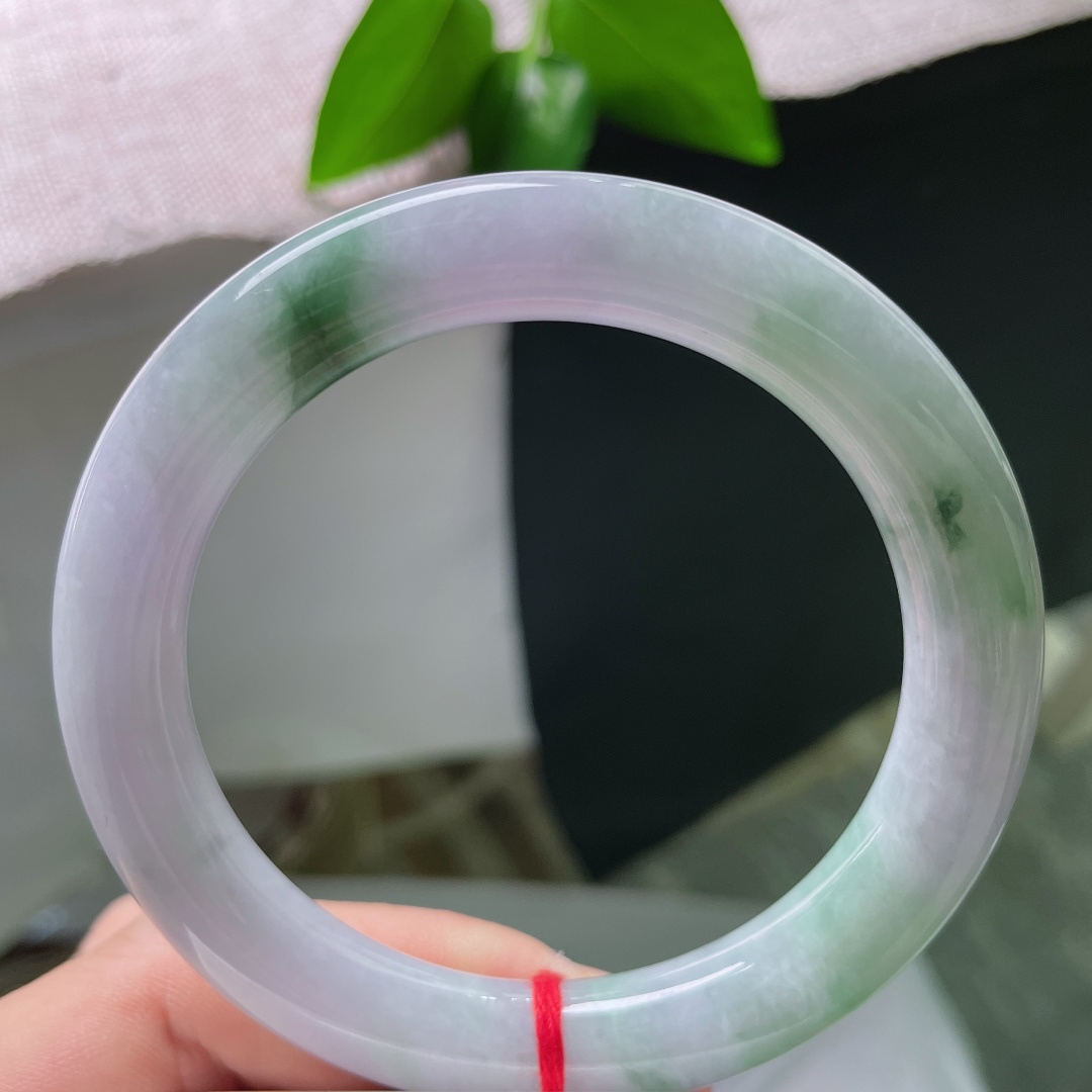 58.8/10.5，紫底飘花，横纹，玉质温润细腻，镯身带着淡淡的紫底，一缕缕鲜活绿花悠然晕染开来，上
